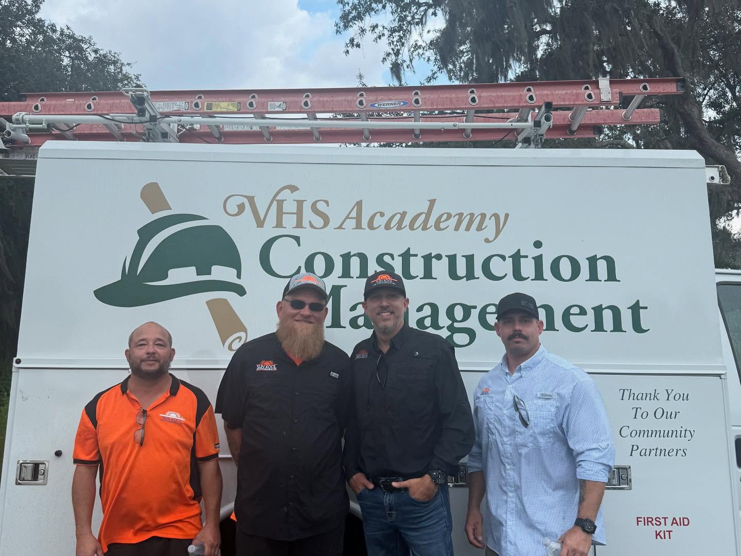 4 people in front of a branded van