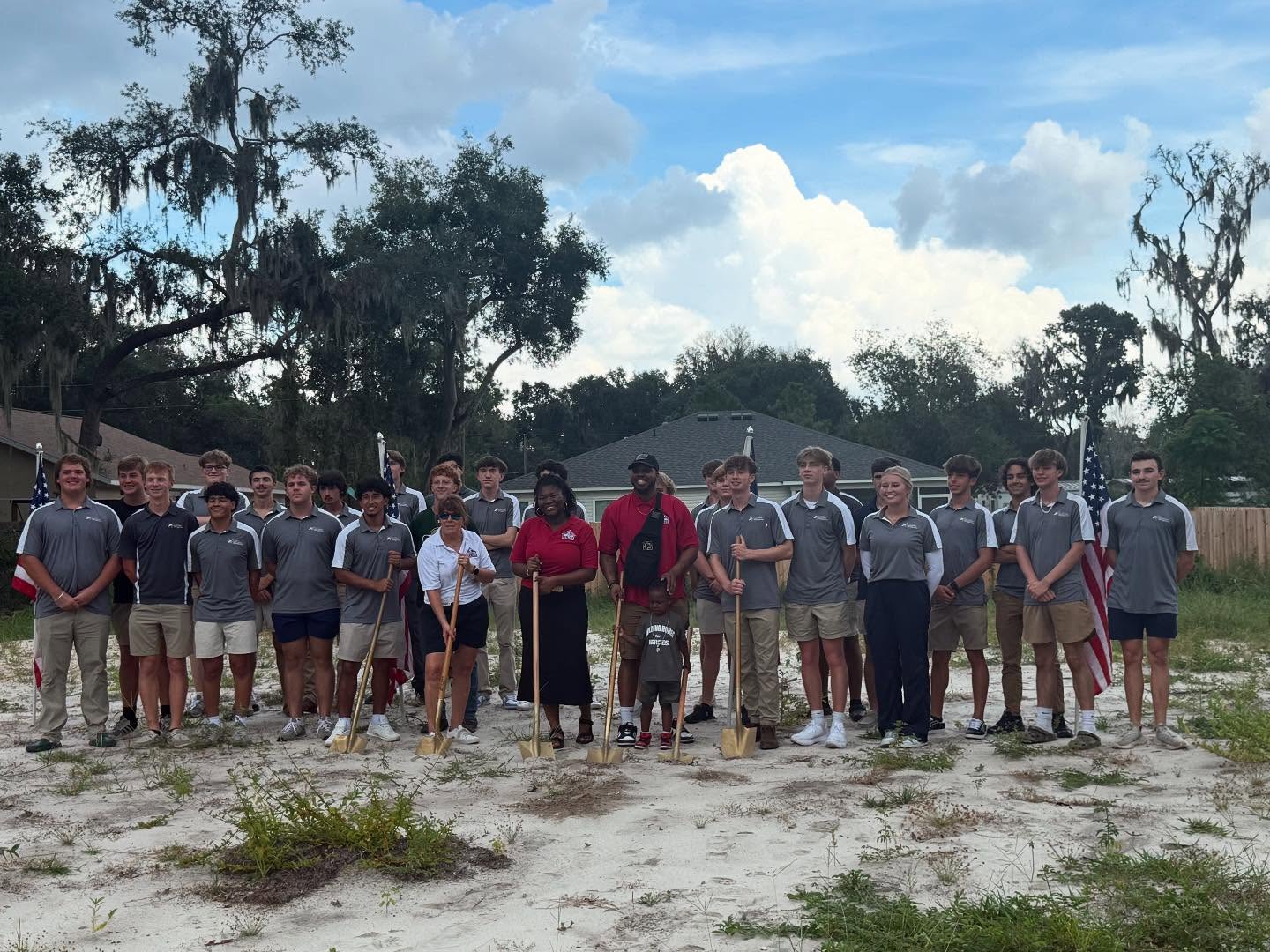 several people standing with shovels